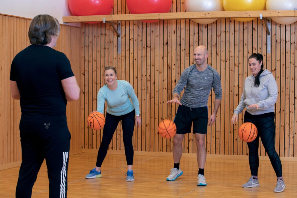 Person som spiller på et piano med to tente lys på toppen, vist fra siden med fokus på hendene og pianotangentene.